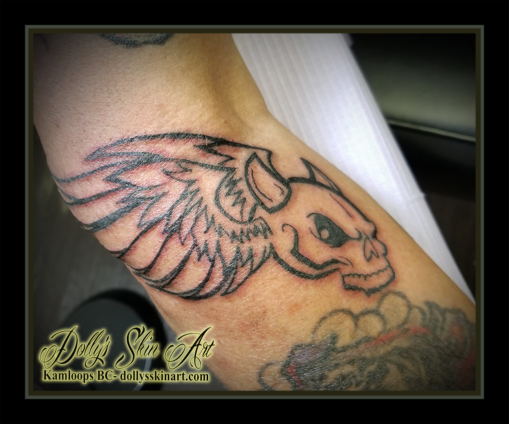 demon skull wings flying feather horns outline blackwork arm tattoo kamloops dolly's skin art