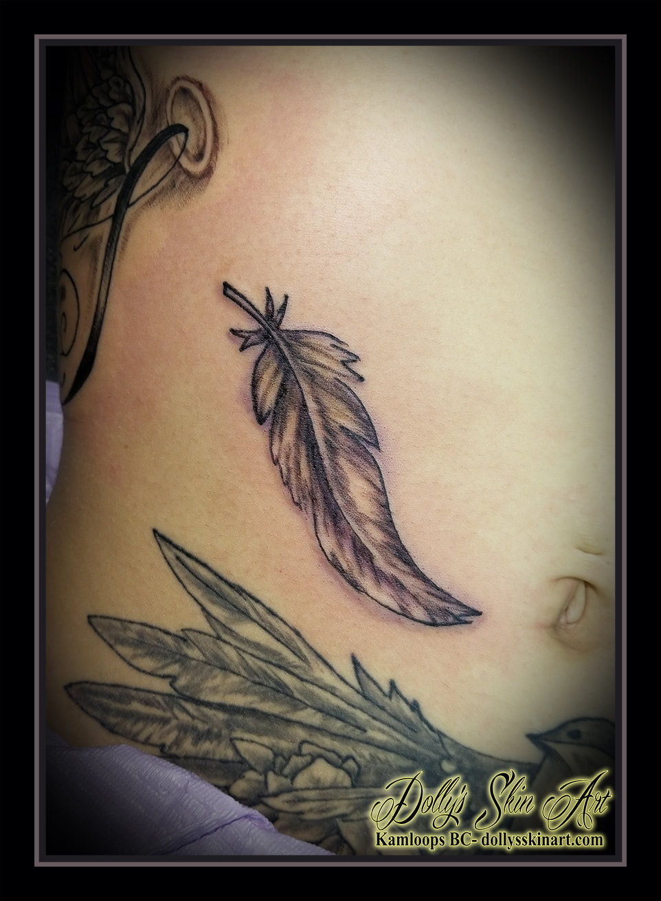 feather tattoo black and grey shaded small stomach cover tattoo kamloops tattoo dolly's skin art