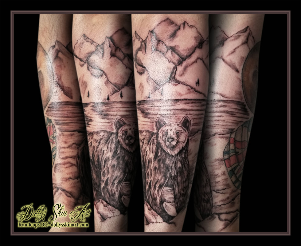 black and grey grizzly bear rocks lake mountains trees forearm half sleeve british columbia tattoo kamloops tattoo dolly's skin art