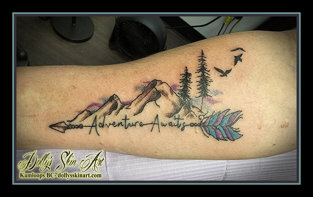 adventure awaits tattoo arrow mountains trees birds forearm black blue purple colour tattoo dolly's skin art kamloops