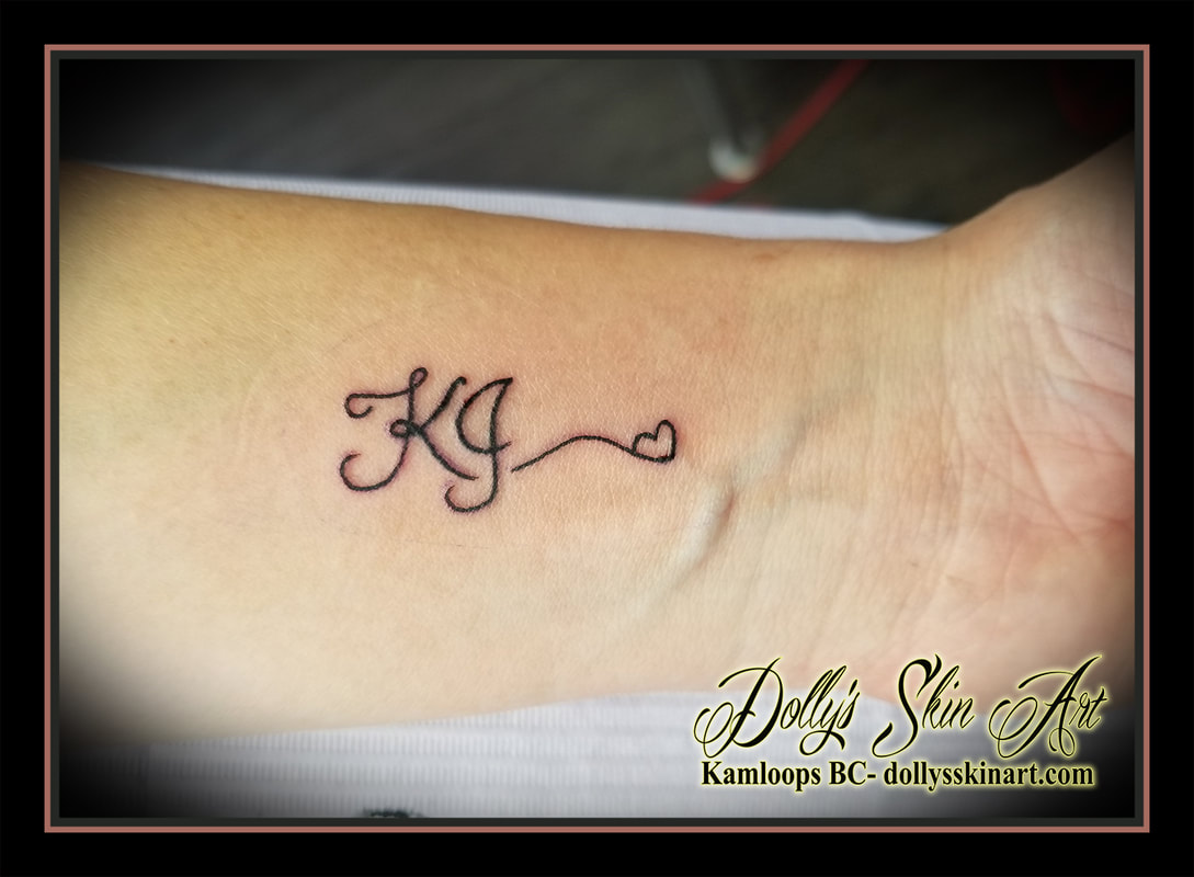 KJ black linework lettering font script heart initials wrist black tattoo kamloops tattoo dolly's skin art