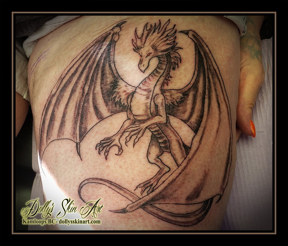 dragon tattoo black and grey shading linework red eyes leg tattoo kamloops dolly's skin art