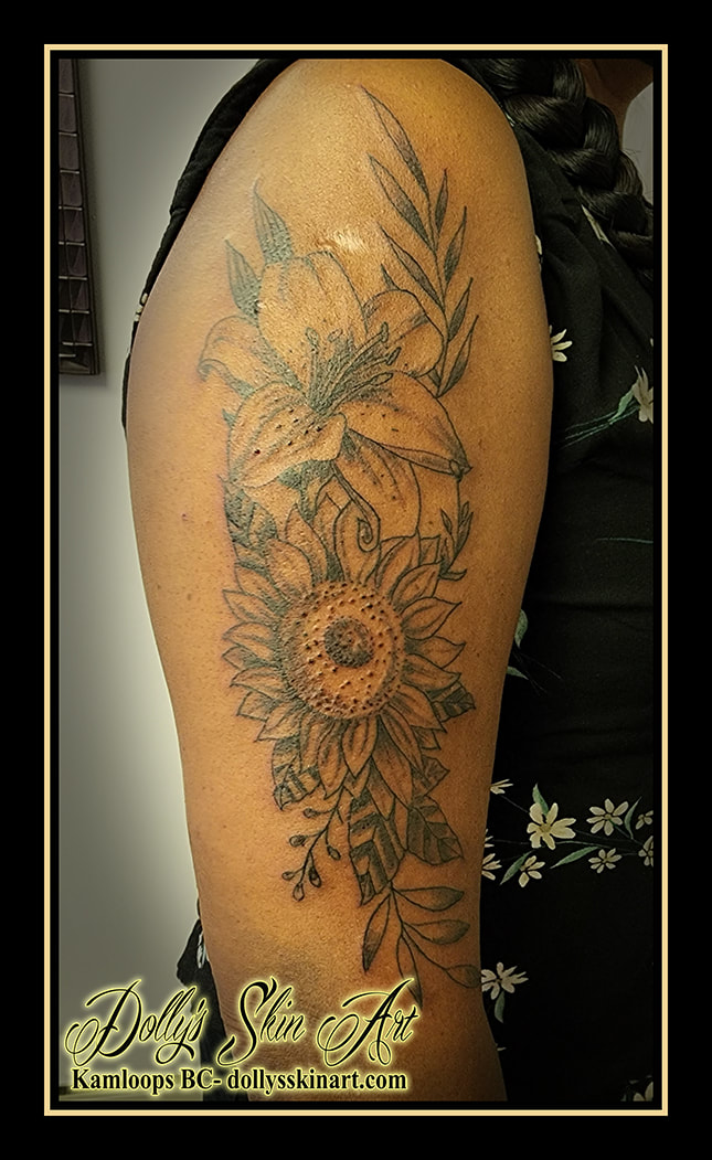 flower tattoo floral arm bicep black and grey shading linework lily sunflower tattoo dolly's skin art kamloops
