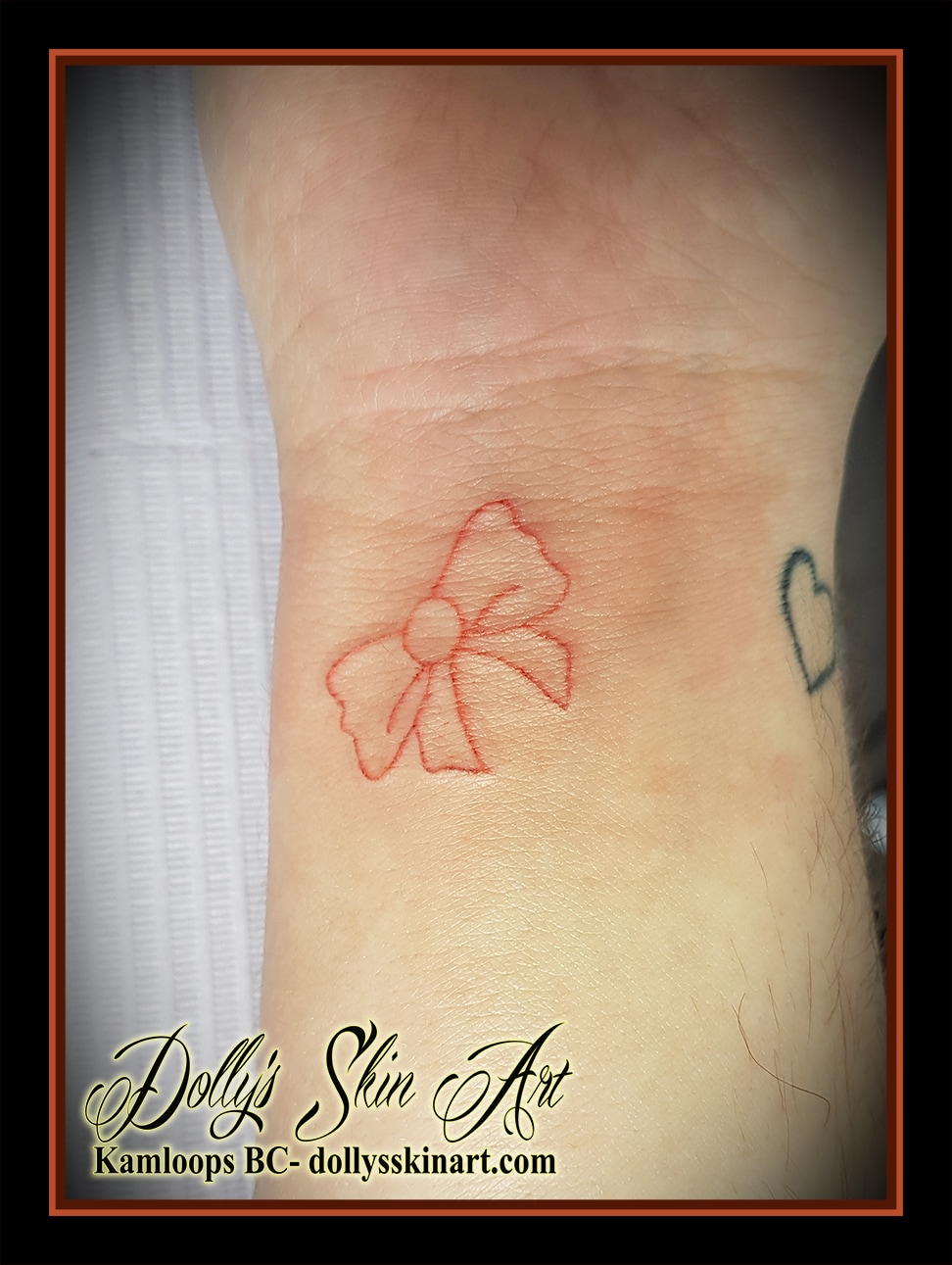 small single line outline bow coral wrist tattoo kamloops dolly's skin art